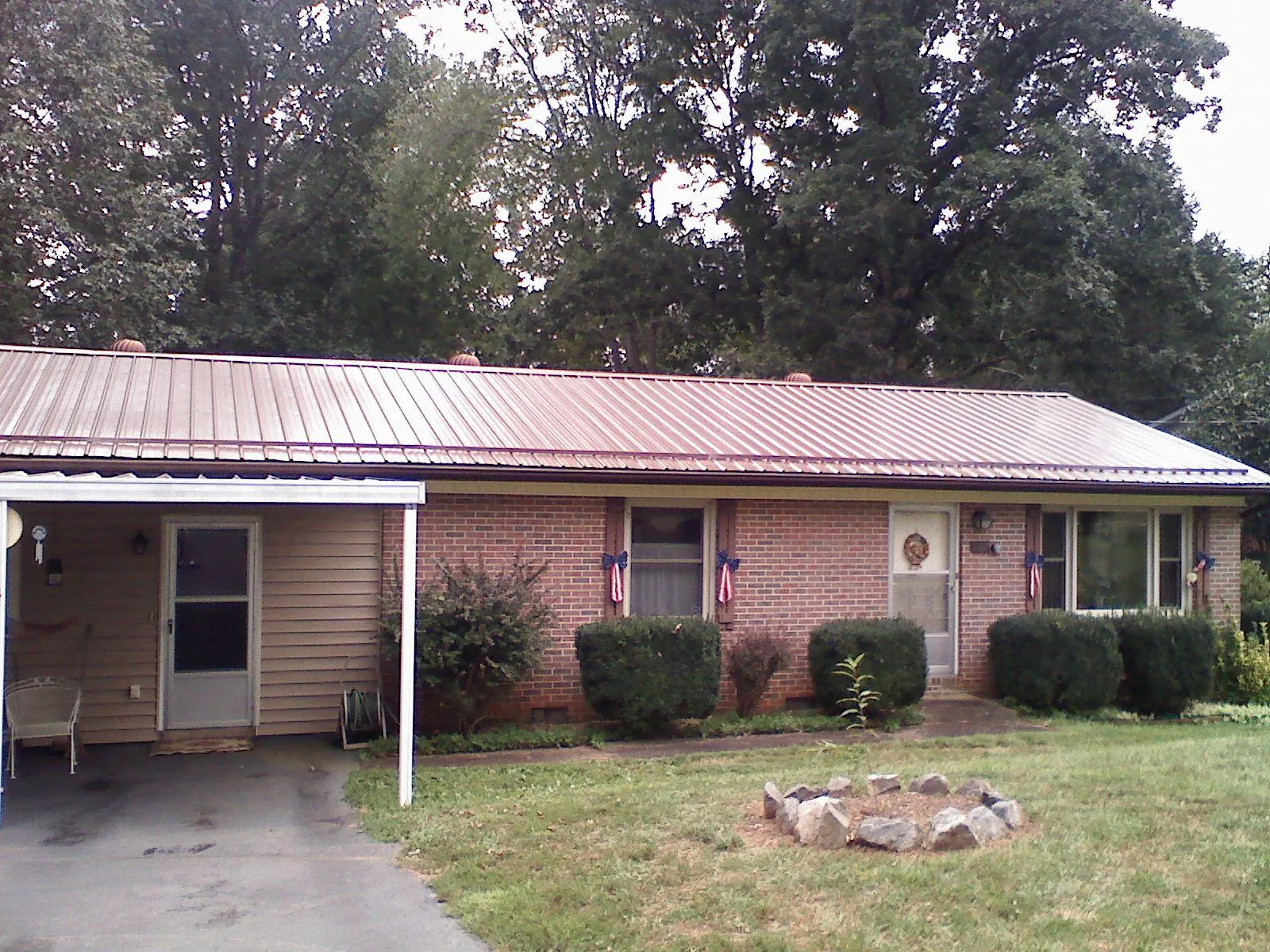 Bronze metal roof and carport on a brick ranch home — Roof Repair work by our crew in Mineville