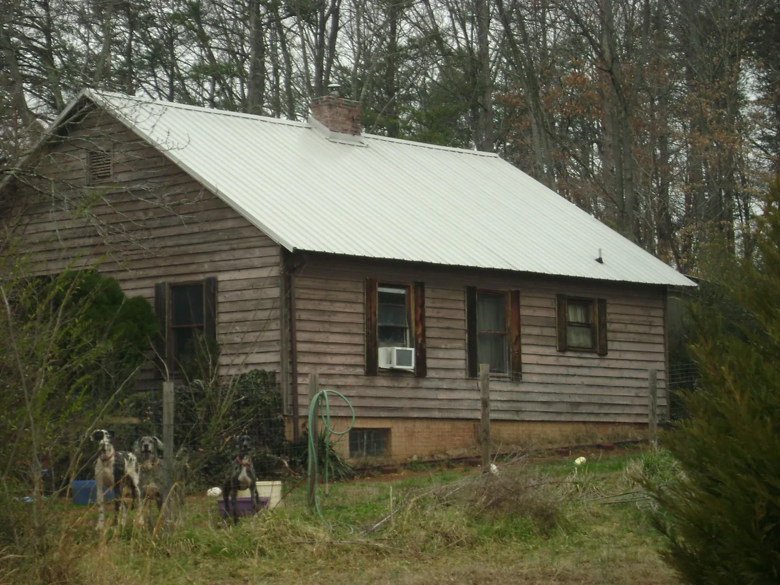 White metal roof on an old wood sided farmhouse, from a Metal Roof Installation job in Mineville